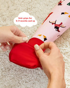 Hands folding a red foot cuff on the Pink Penguins romper, with the original annotation.