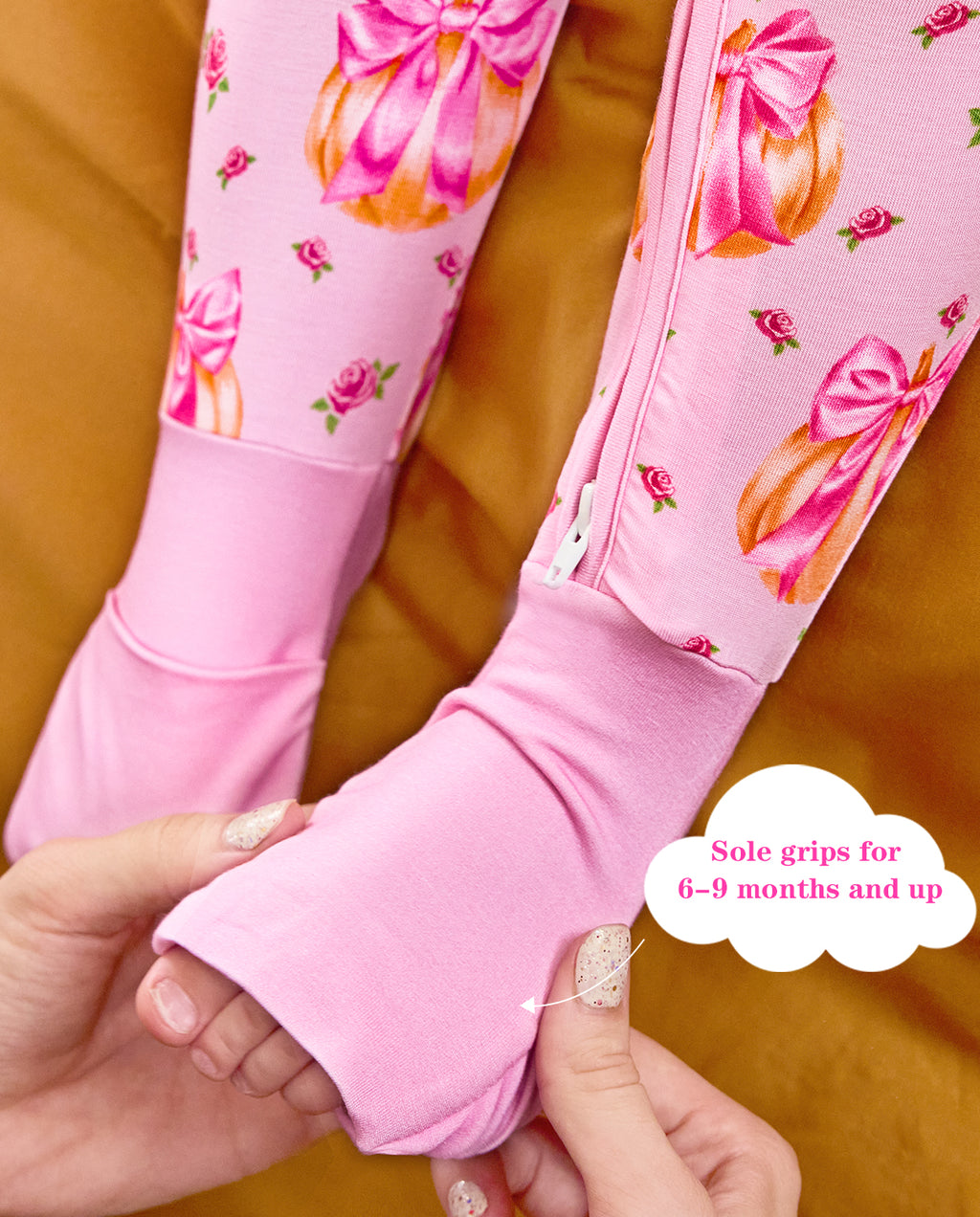 Hands folding a pink foot cuff on the Pumpkin Bows romper, with the original annotation.
