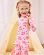 Smiling child standing with a hand near the face in Pumpkin Bows pajamas.