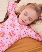Child reclining on bedding in the Pumpkin Bows two-piece pajama set.