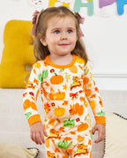 Close front view of a seated child wearing Pumpkin Patch pajamas.