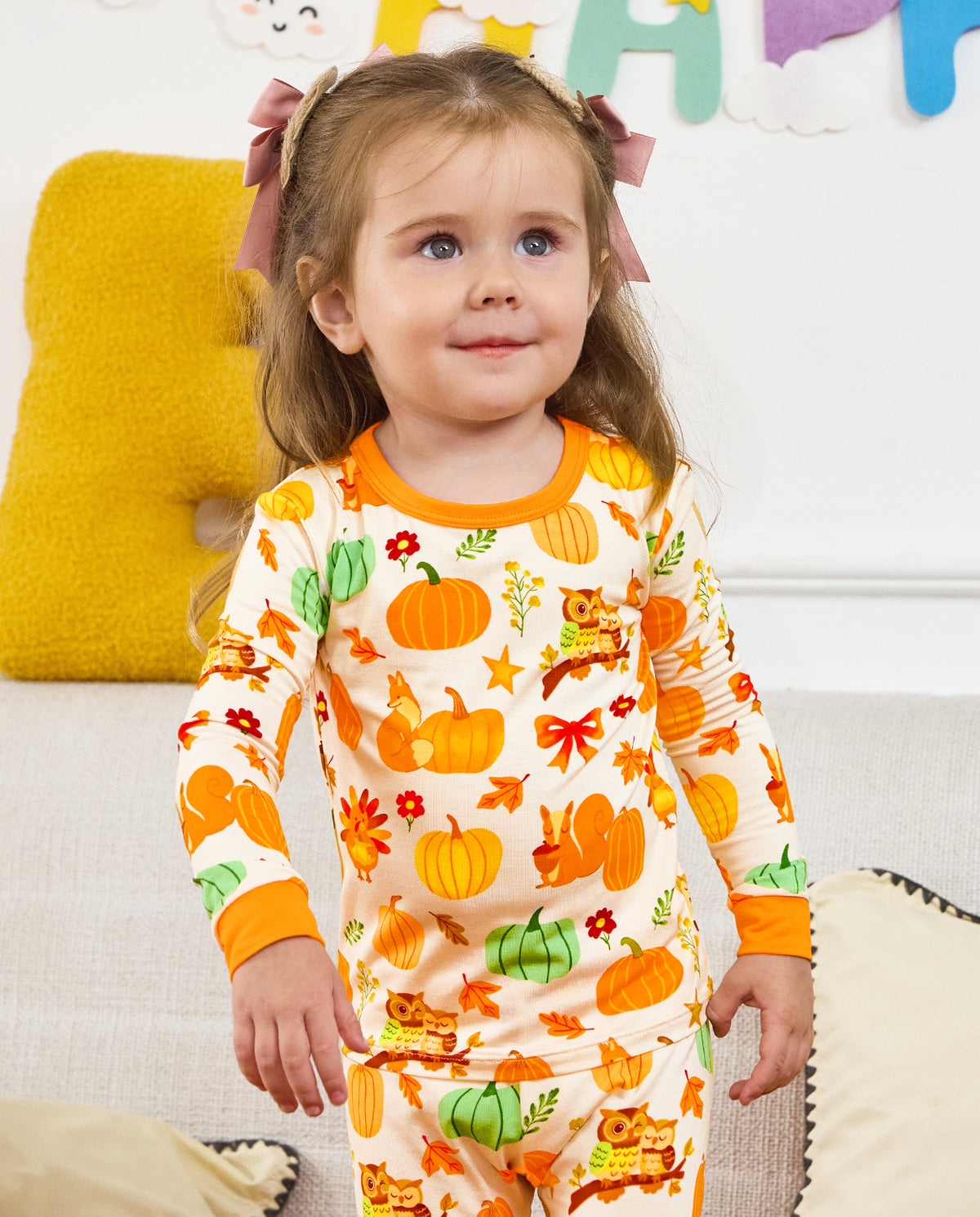 Close front view of a seated child wearing Pumpkin Patch pajamas.