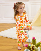 Front view of a child standing beside a cart in Pumpkin Patch pajamas.