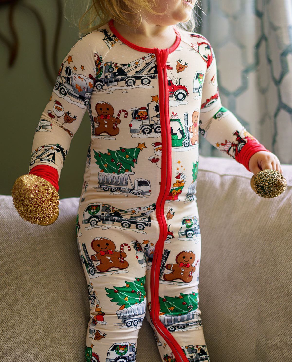 Close view of Santa Express zippy showing the red zipper and festive trucks as a child holds ornaments