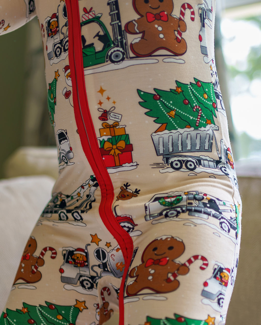 Close detail of Santa Express fabric showing a truck carrying a Christmas tree beside the red zipper