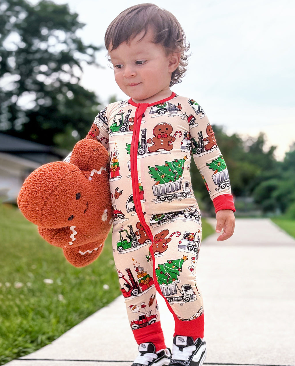 Child looking down at a gingerbread toy while wearing Santa Express zippy outdoors