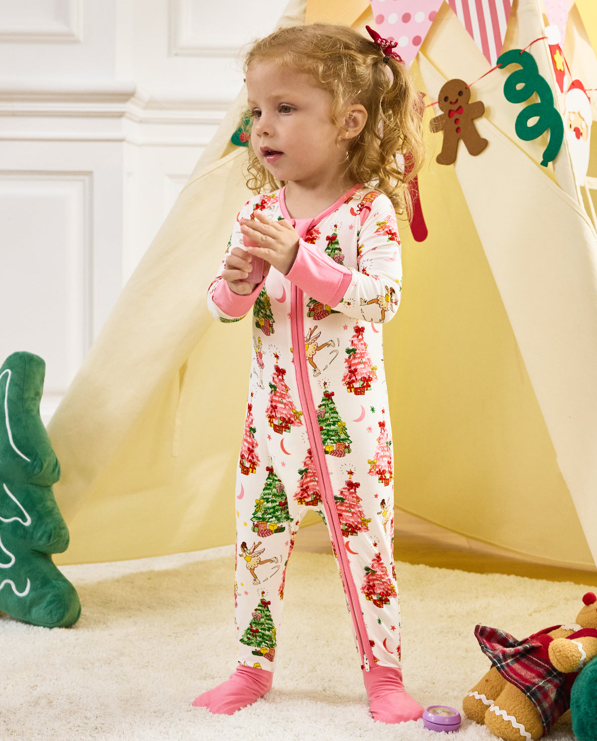 Child standing beside a tent in the Snuggle Sparkle zip-up romper.
