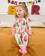 Child seated on orange bedding in the white Snuggle Sparkle romper.