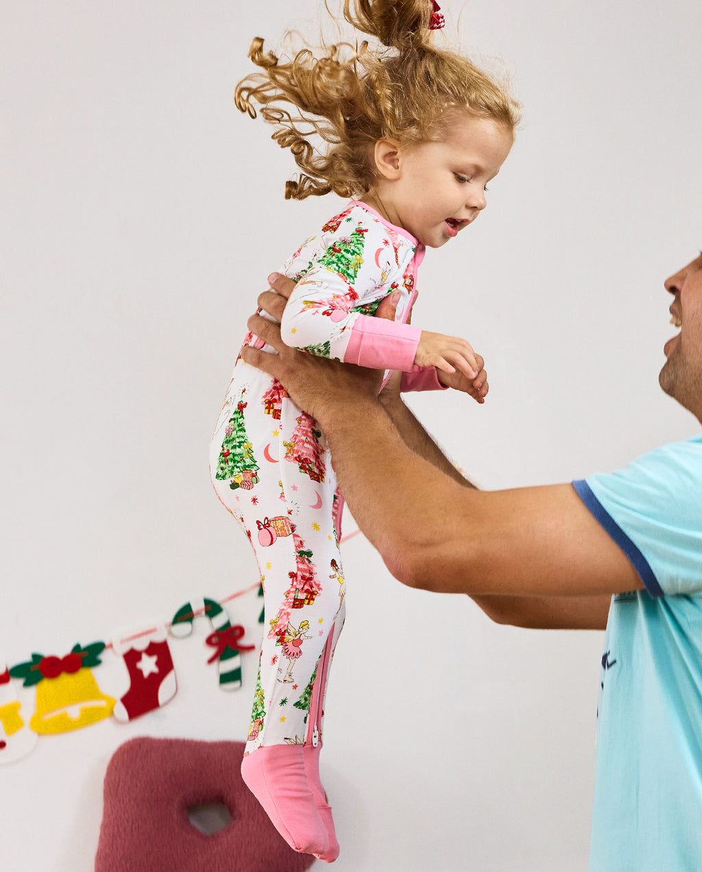 Side view of a child standing in the Snuggle Sparkle romper with pink cuffs.
