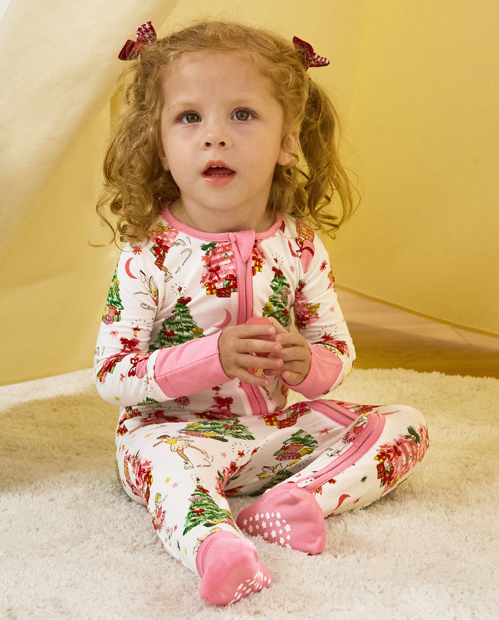 Child seated holding a toy in the Snuggle Sparkle romper.