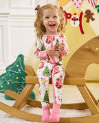 Child smiling on a wooden tricycle in the Snuggle Sparkle romper.