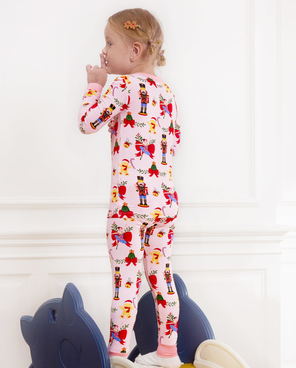 Rear view of a child standing with a lollipop in the Sugarplum Wishes pajama set.