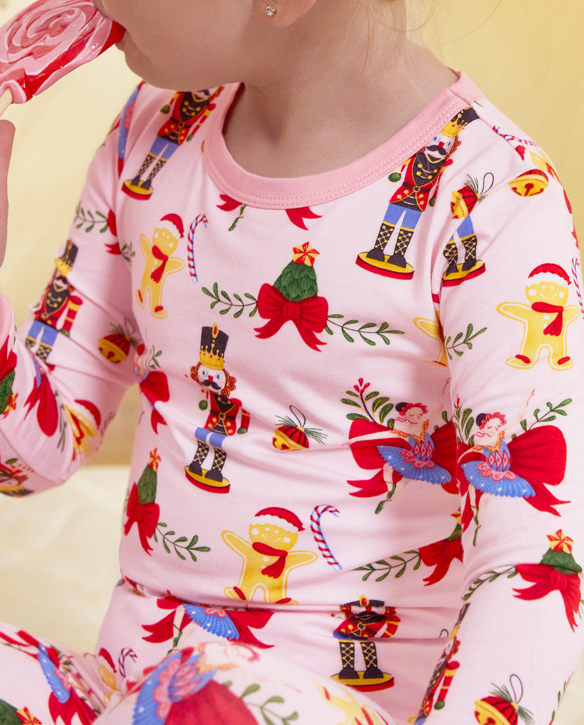 Close-up of the pink neckline, nutcrackers and ribbon motifs on the Sugarplum Wishes top.