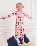 Child standing with arms out on a slide in Sugarplum Wishes pajamas.