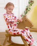 Child looking downward while seated on a wooden rocking horse in Sugarplum Wishes pajamas.