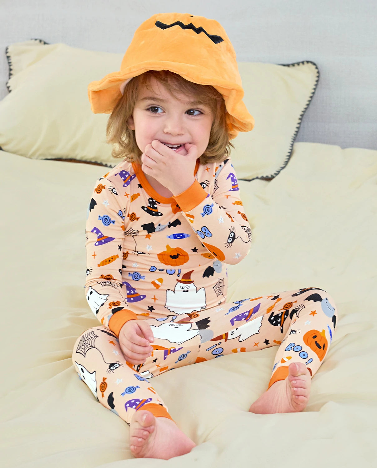 Boo Treats Long Two-Piece Pajama Set - child wearing the pajamas while seated in an orange pumpkin hat