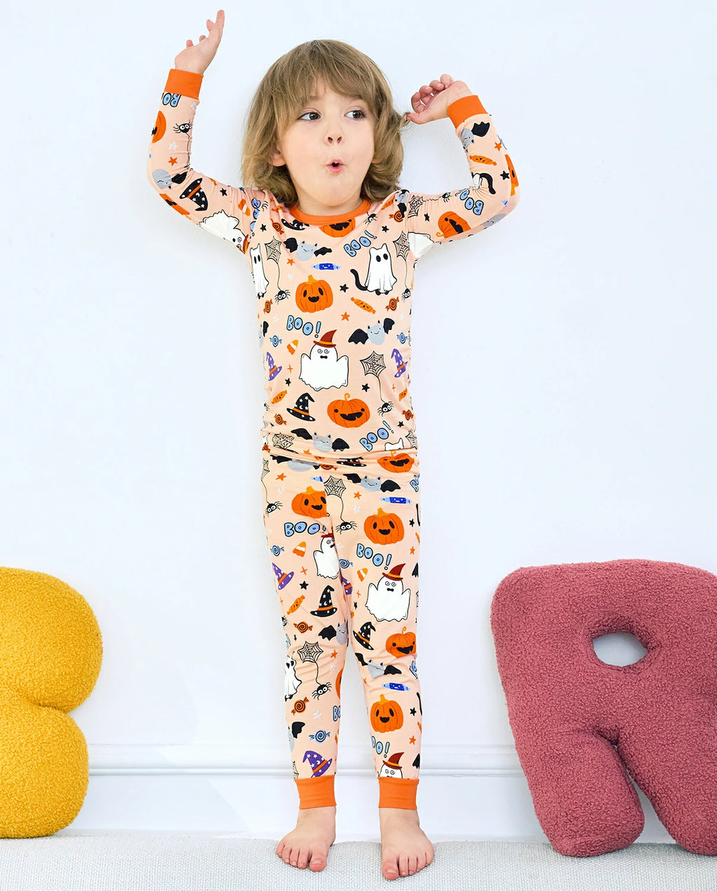 Boo Treats Long Two-Piece Pajama Set - child wearing the pajamas with both arms raised, full-length view