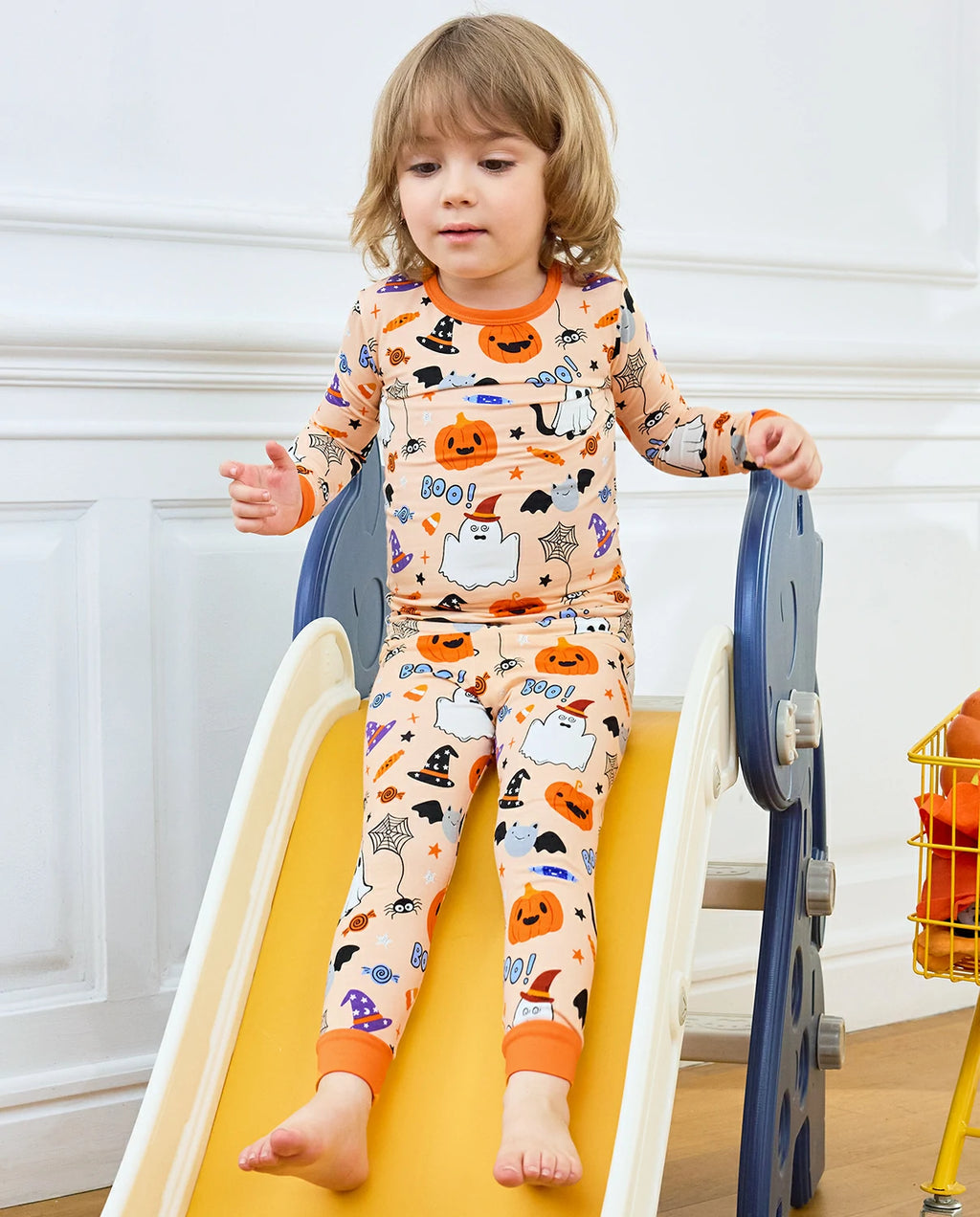 Boo Treats Long Two-Piece Pajama Set - child wearing the pajamas while seated on a play slide
