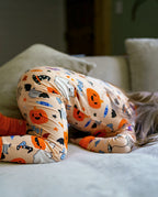 Child curled on couch in Boo Treats Bamboo Zippy showing flexible stretch for play