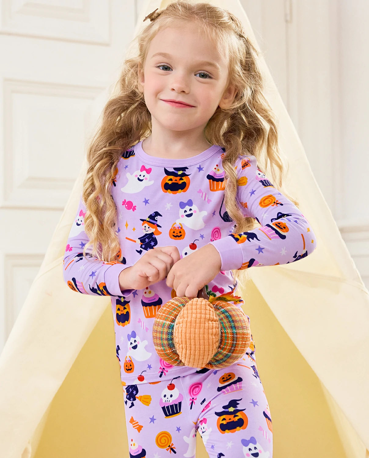 Candy Boo Long Two-Piece Pajama Set - child wearing the pajamas while standing with a plush pumpkin