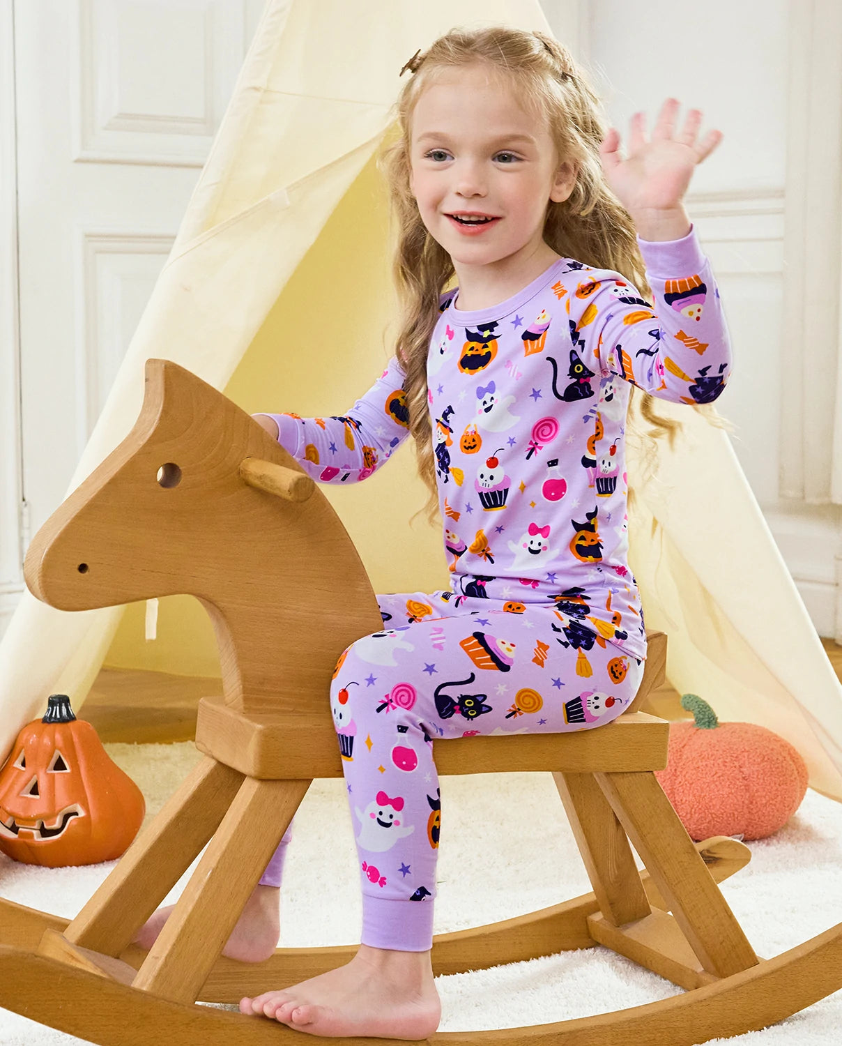 Candy Boo Long Two-Piece Pajama Set - child wearing the pajamas on a rocking horse while waving