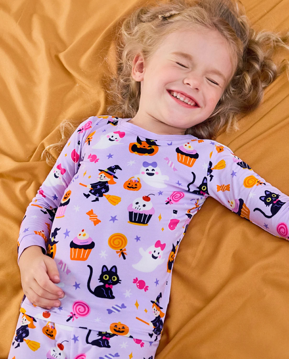 Candy Boo Long Two-Piece Pajama Set - child wearing the purple Halloween pajamas while reclining