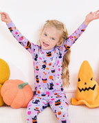 Candy Boo Long Two-Piece Pajama Set - child wearing the pajamas while seated with both arms raised