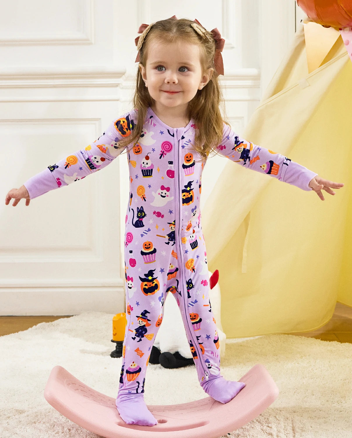 Child wearing Candy Boo Bamboo Zippy Halloween pajamas during indoor play