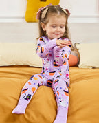 Baby wearing Candy Boo Bamboo Zippy while relaxing on a bed