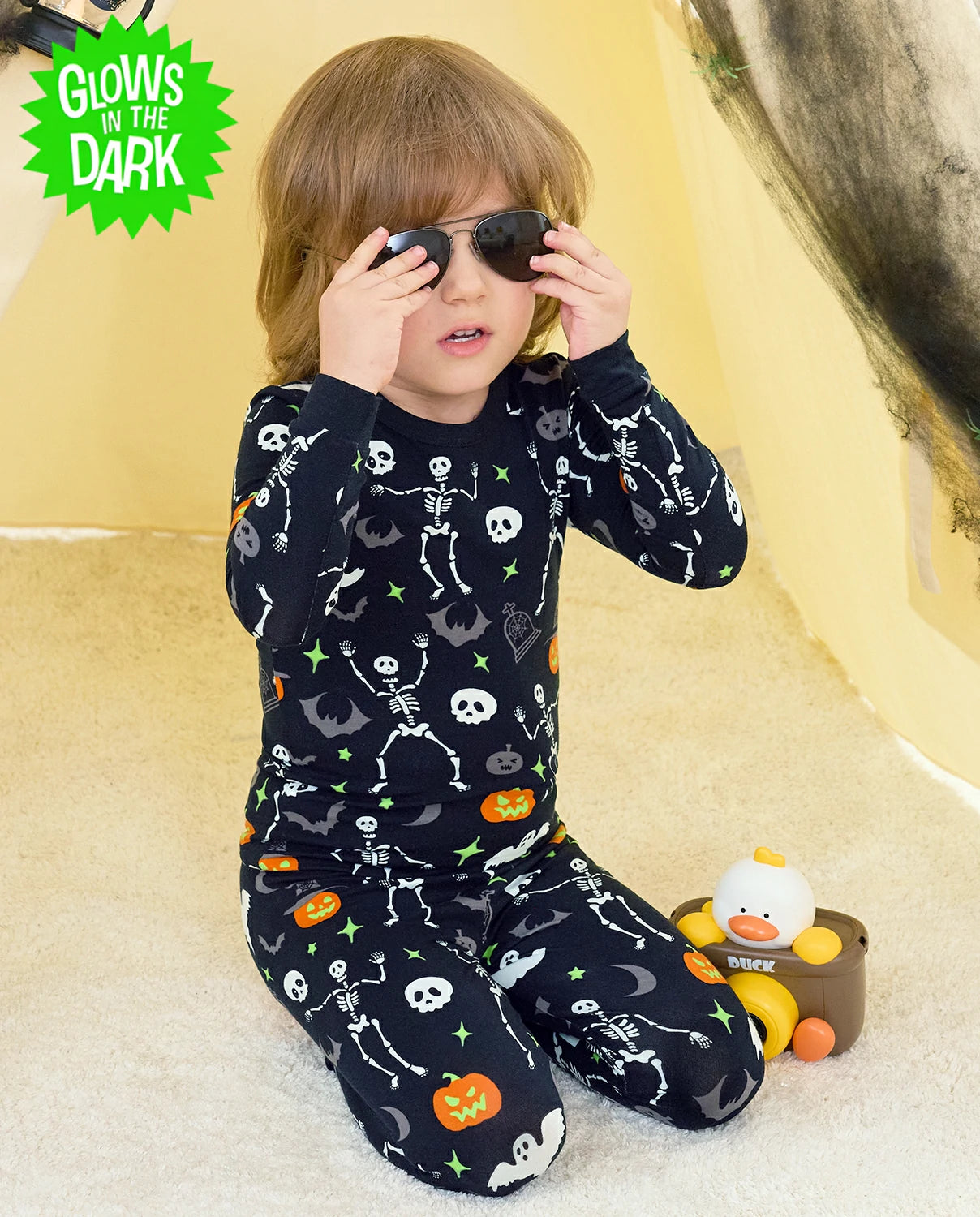 Dark Disco Long Two-Piece Pajama Set - child wearing the glow-print pajamas while holding sunglasses