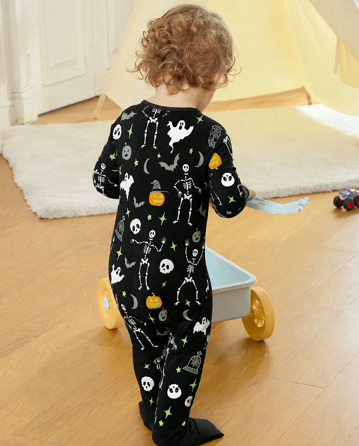 Back view of child wearing Dark Disco Bamboo Zippy while playing indoors with a toy wagon