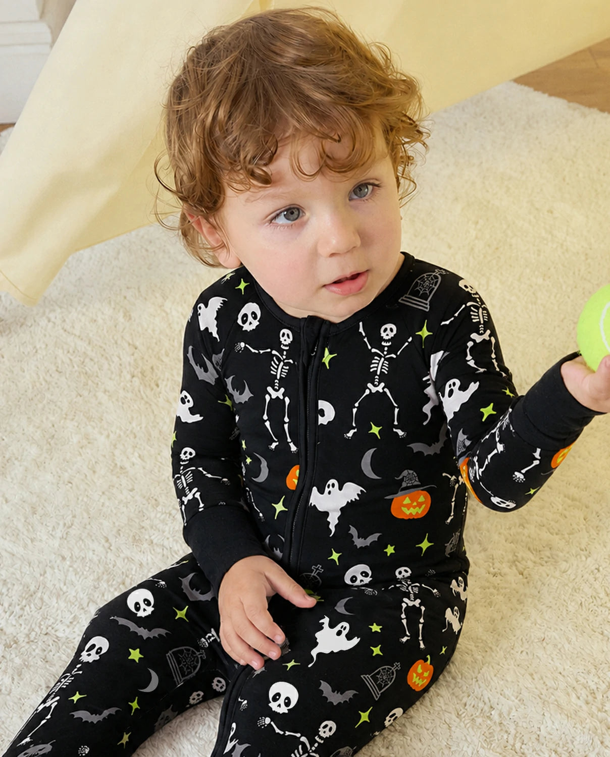 Child sitting in Dark Disco Bamboo Zippy with black Halloween print and soft bamboo fabric