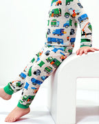 Side view of a child seated on a white chair in Garbage Squad pajamas