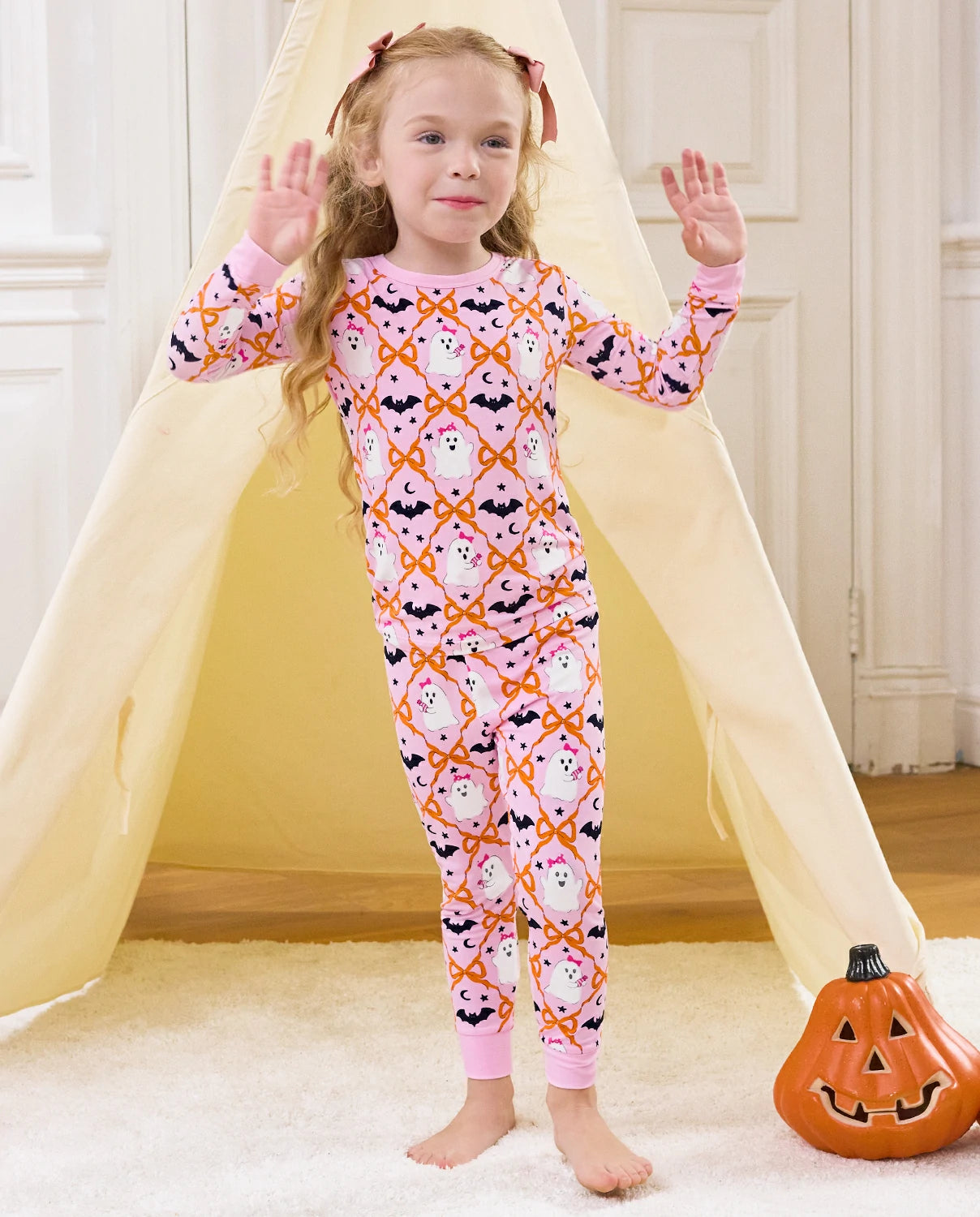 Ghost Bows Long Two-Piece Pajama Set - child wearing the ghost-and-bow pajamas with both arms raised