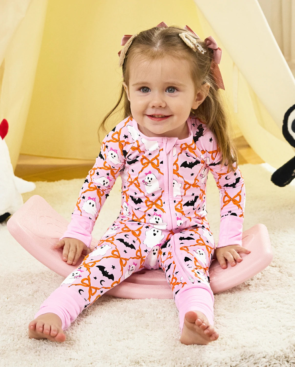 Baby wearing pink Ghost Bows Bamboo Zippy showing soft Halloween print and comfortable fit
