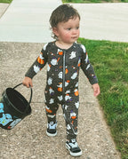 Toddler wearing Ghostie Sports Club Bamboo Zippy standing outdoors with Halloween bucket and sneakers
