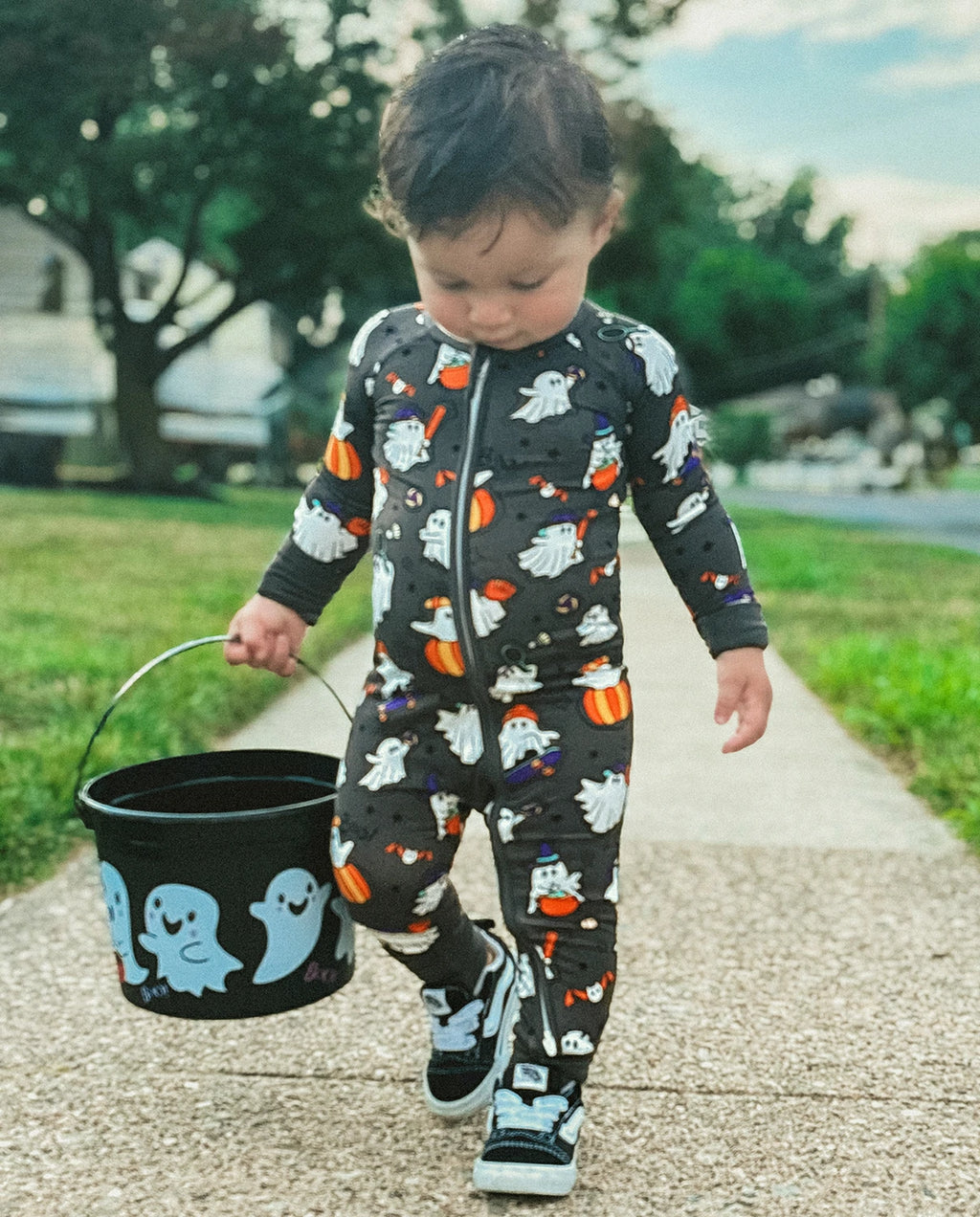 Toddler walking outdoors in Ghostie Sports Club Bamboo Zippy carrying a Halloween ghost bucket