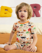 Happy Farmyard Short Two-Piece Pajama Set - child wearing the short pajamas while seated, portrait view