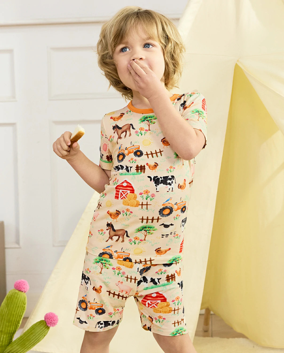 Happy Farmyard Short Two-Piece Pajama Set - child wearing the short pajamas while standing with a snack