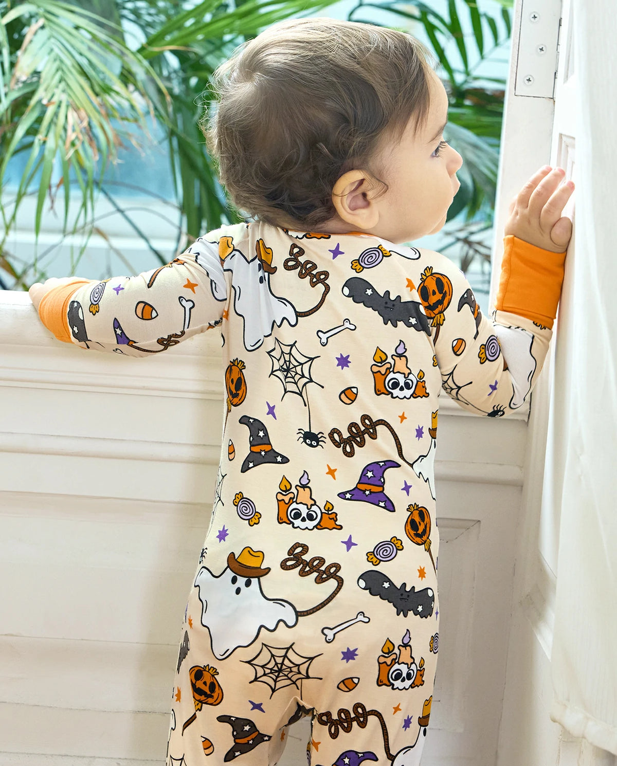 Smiling baby in Happy Hallowboo Bamboo Zippy with Halloween ghost and pumpkin print