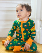 Front view of a baby seated in Harvest Feast Bamboo Zippy with orange fold-over cuffs.