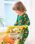 Child wearing Harvest Feast long two-piece pajamas while playing with a yellow toy shopping cart.