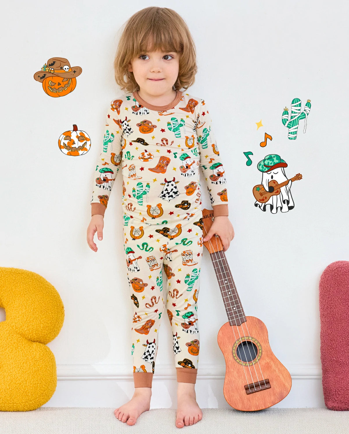 Howdy Halloween Long Two-Piece Pajama Set - child wearing the pajamas while standing beside a ukulele
