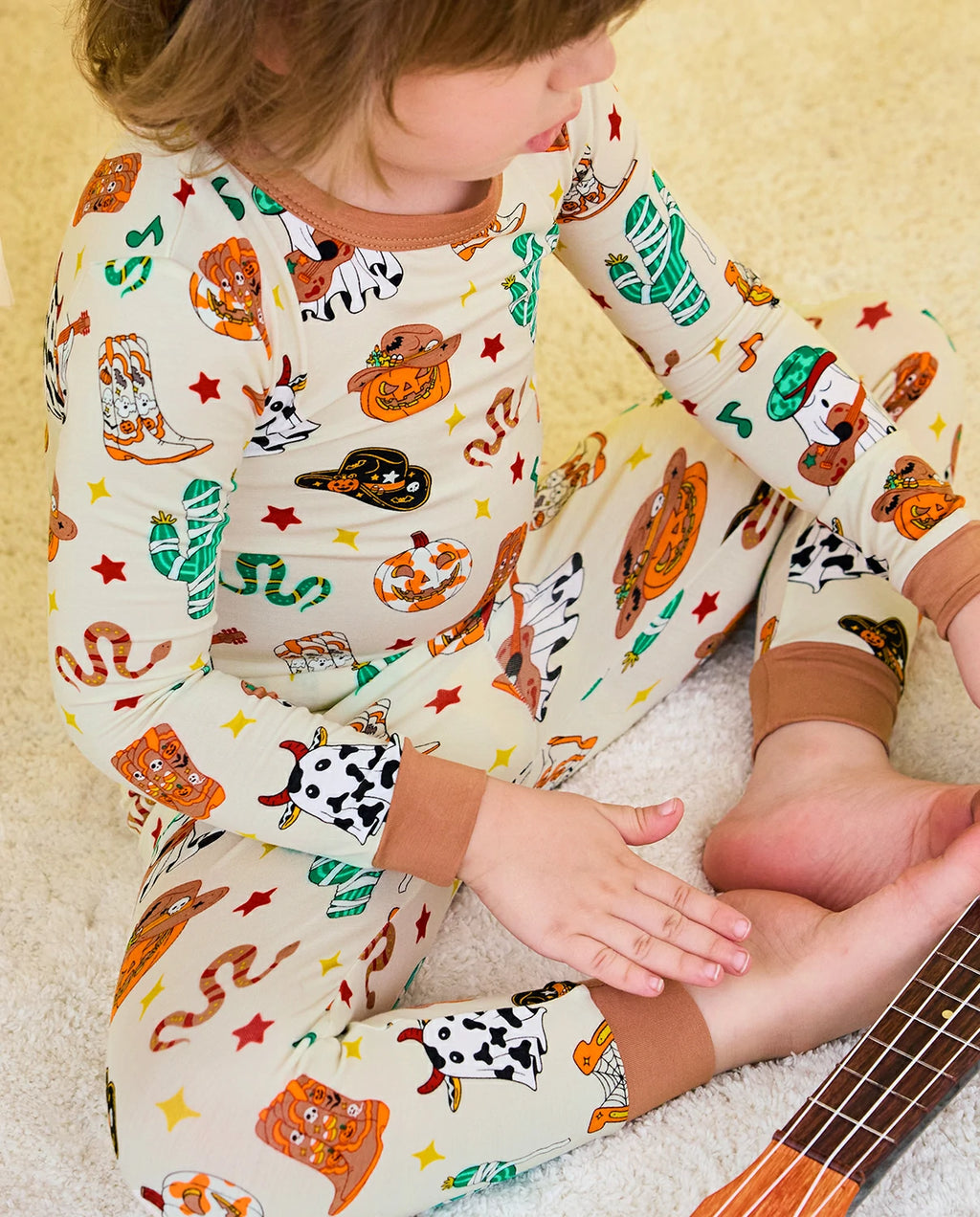 Howdy Halloween Long Two-Piece Pajama Set - close-up of the pajama legs and brown cuffs while seated