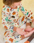 Howdy Halloween Long Two-Piece Pajama Set - close-up of the pajama legs and brown cuffs while seated