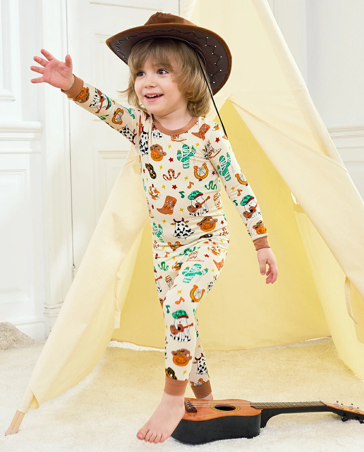 Howdy Halloween Long Two-Piece Pajama Set - child wearing the pajamas while standing with one arm raised