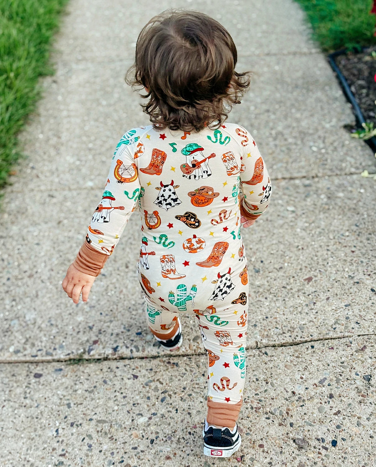 Back view of child walking in Howdy Halloween Bamboo Zippy with cowboy ghost and pumpkin print