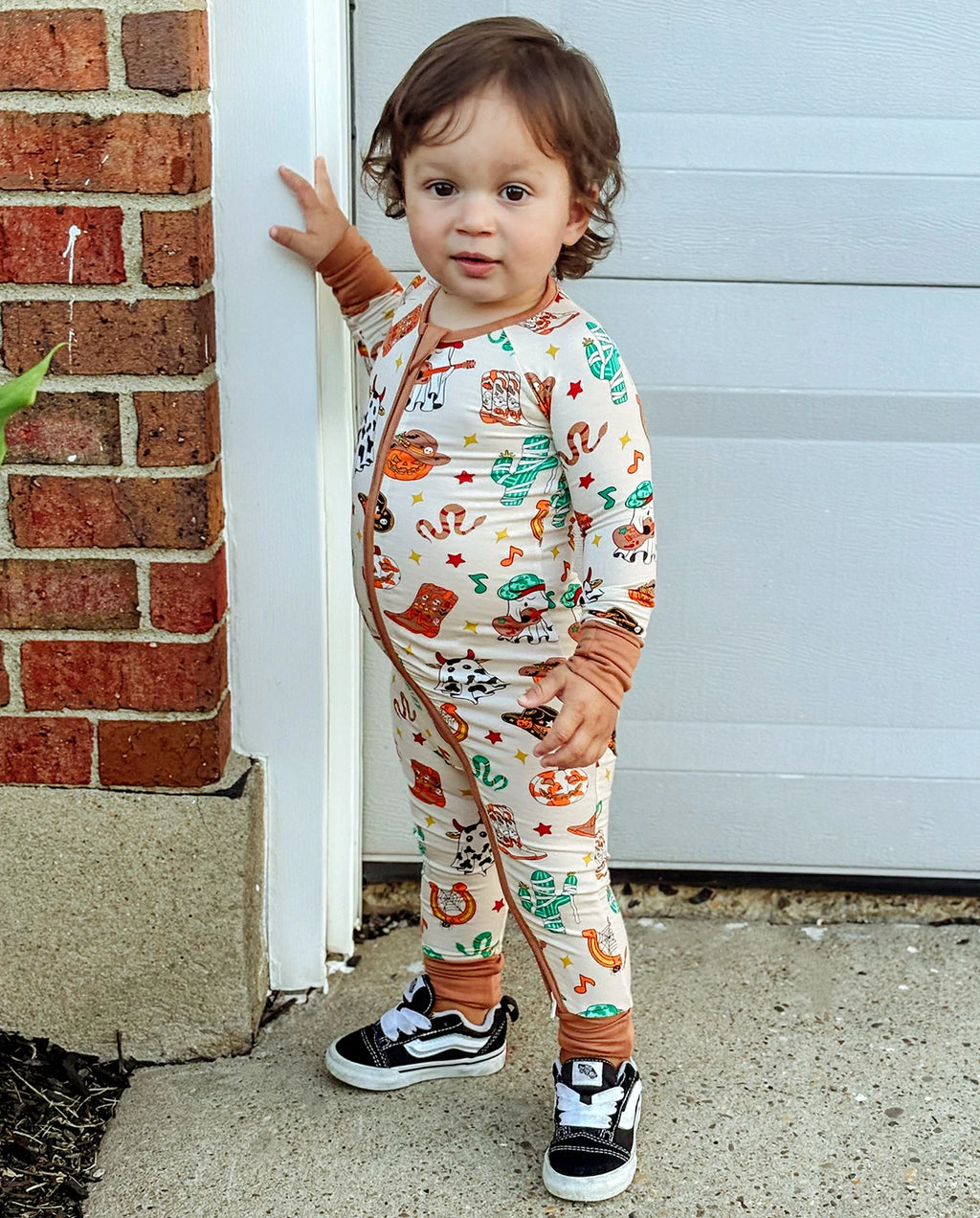 Child wearing Howdy Halloween Bamboo Zippy standing by a garage door outdoors