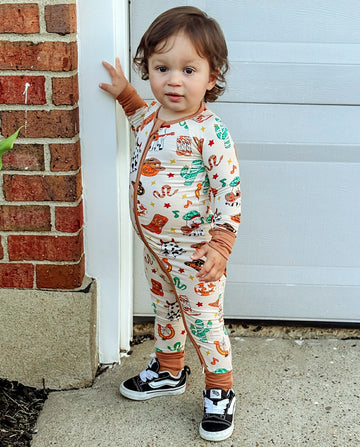 Child wearing Howdy Halloween Bamboo Zippy standing by a garage door outdoors