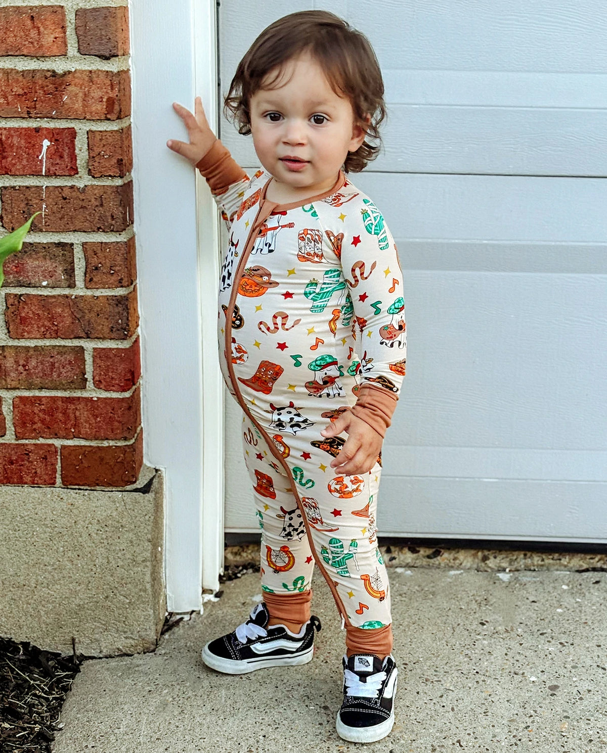 Child wearing Howdy Halloween Bamboo Zippy standing by a garage door outdoors